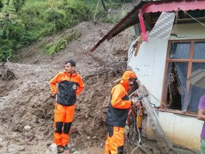 जुन्गा के जोट गांव में भूस्खलन से मलबे में दबा मकान और मौके पर राहत कार्य करती टीम।