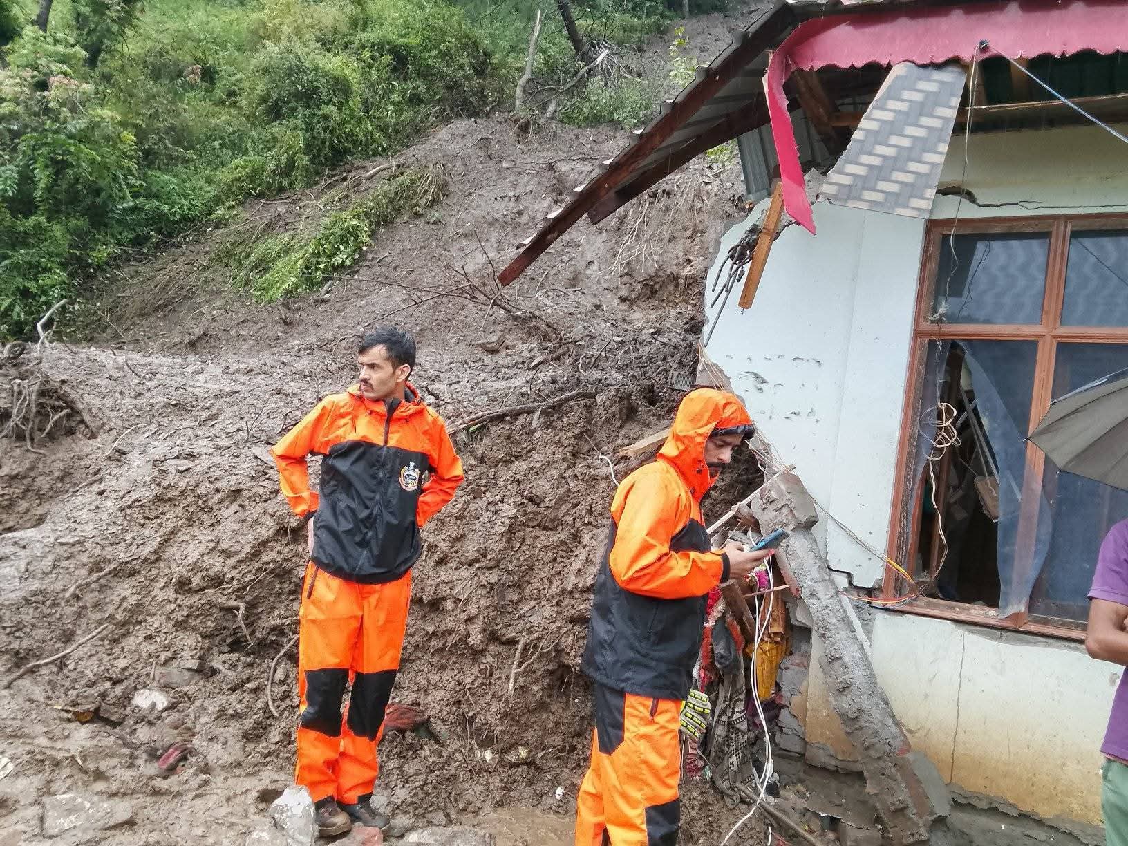 जुन्गा के जोट गांव में भूस्खलन से मलबे में दबा मकान और मौके पर राहत कार्य करती टीम।